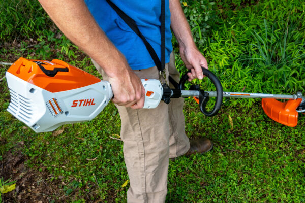VS Landscape Group Professional landscaper trimming grass with a STIHL battery-powered string trimmer in Ottawa.